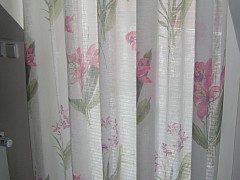 Die schönste Kombination für ein weißes Wohnzimmer - Gardinen und ein Überwurf in rosa, lila und mit Orchideen-Blüten